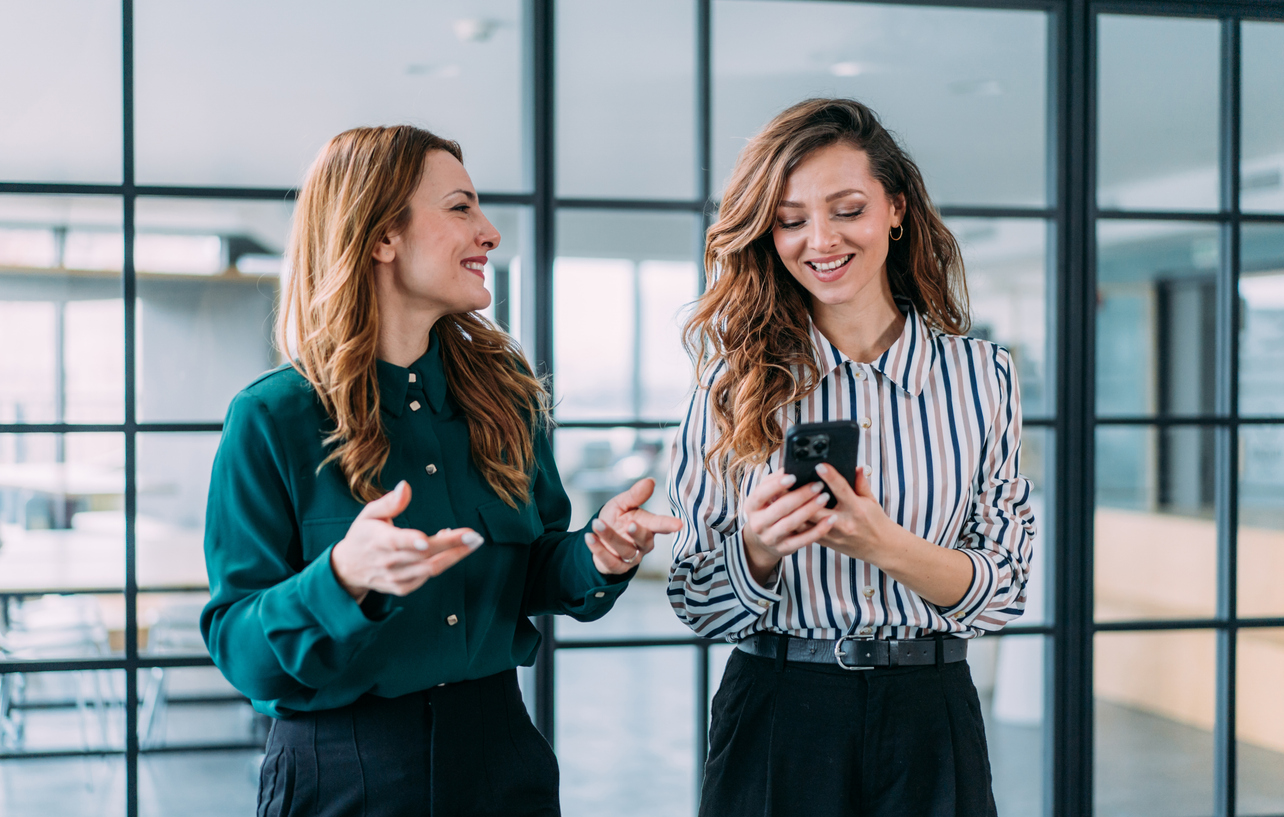 Two colleagues reviewing results on a phone